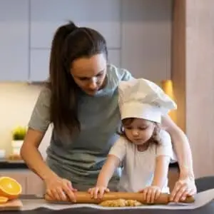 Mother is helping her daughter in cooking-Mother’s Day activities for kids