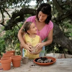 Mother is helping her daughter in planting-Mother’s Day activities for kids