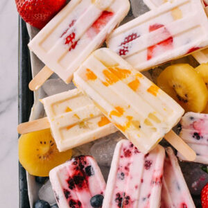 fruit and yogurt popsicles with berries and honey frozen into healthy summer treats for kids.