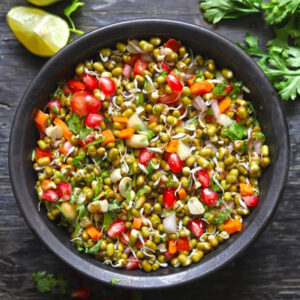Fresh sprout chaat with mixed sprouts, paneer cubes, tomatoes, onions, carrots, and lemon in a healthy kids snack bowl.