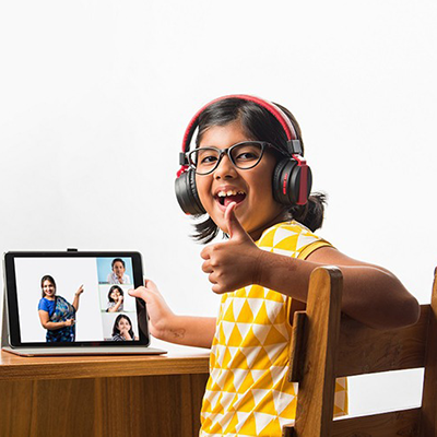 A child wearing headphones and giving thumbs up